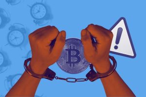 Stylized image shows hands held out with handcuffs around them. There's a Bitcoin and a warning symbol beside the hands. The background contains multiple alarm clocks.